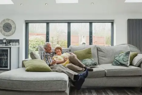 Retired couple enjowing a drink on the sofa